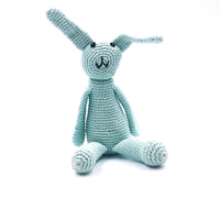 My First Bunny. Handmade with 100% organic cotton + 100% polyester fill. This toy has a rattle.  Ages 0+ older child. Approximately 22 cm length + 7.5 cm width. Made in Bangladesh for Refuge Brands.. Light Turquoise.